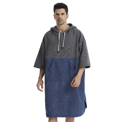 Man wearing a Quick-Dry Hooded Towel Poncho in grey and navy, ideal for surfing and beach adventures.