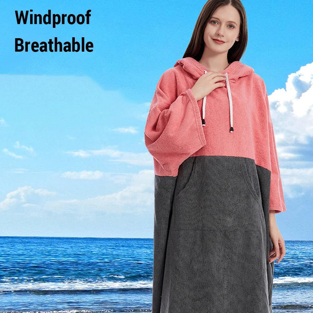 Woman wearing a pink and gray quick-dry hooded towel poncho by the beach, showcasing its windproof and breathable design.