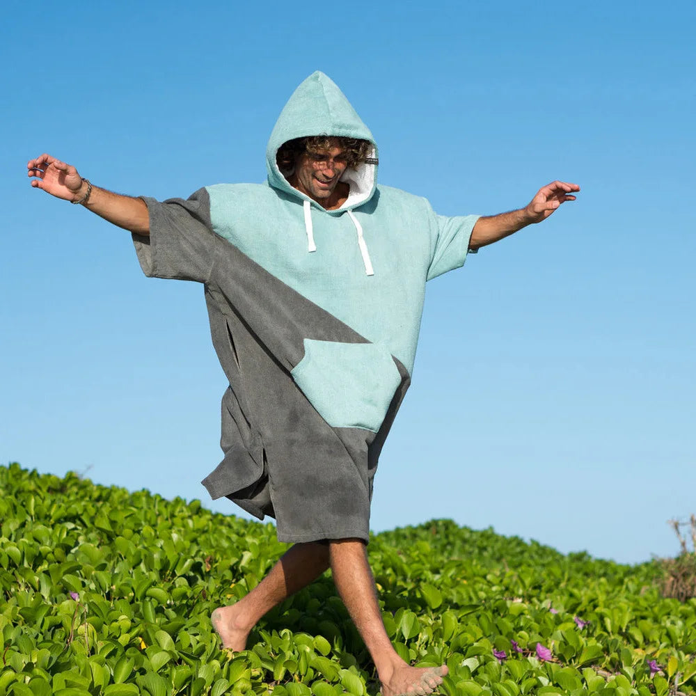 Man wearing a blue and gray thickened hooded bathrobe poncho on a sunny beach, ideal for swimming and diving activities.