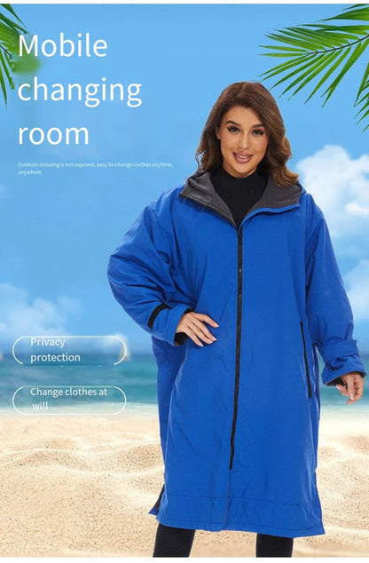 Woman in a blue mobile changing room poncho by the beach, showcasing privacy protection for outdoor clothing changes.