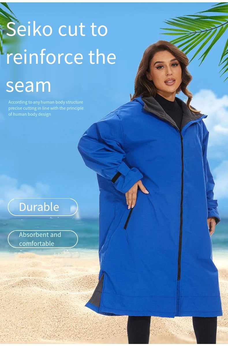 Woman wearing a durable blue hooded robe, designed for comfort and warmth, against a beach backdrop.