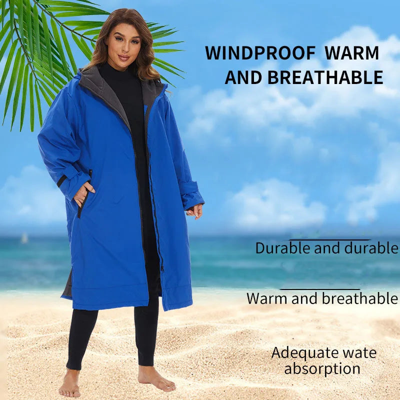 Woman wearing a blue windproof, warm, and breathable changing robe by the beach, showcasing its durability and water absorption features.