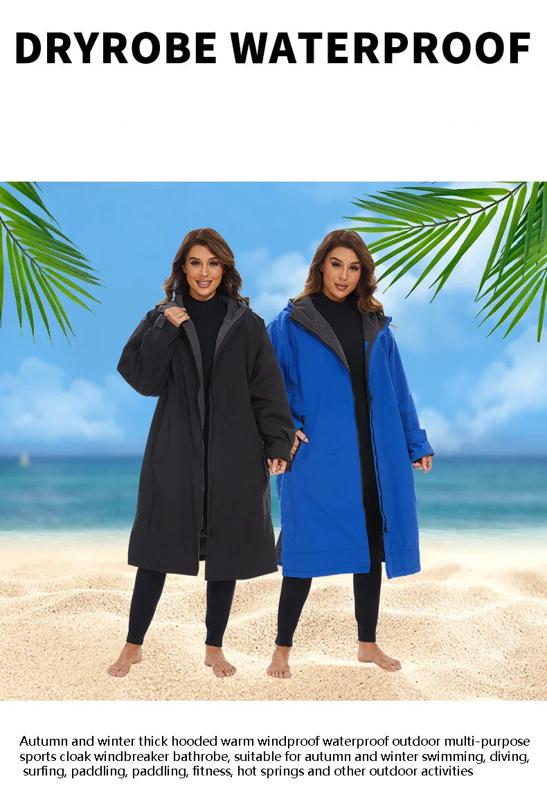 Two women wearing waterproof dryrobes in black and blue on the beach, perfect for winter water sports and outdoor activities.