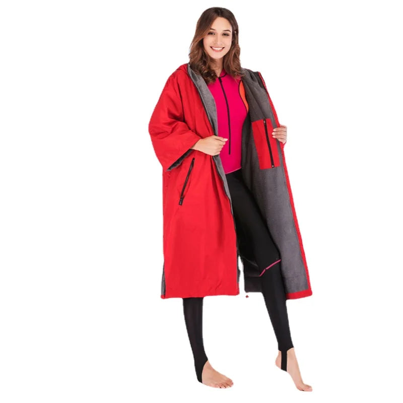 Woman wearing a waterproof surf changing robe, showcasing its fleece lining and spacious design for outdoor activities.