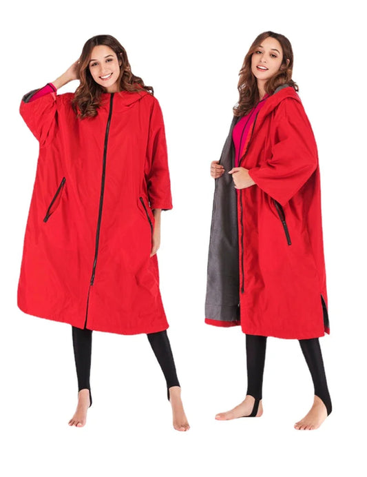 Waterproof surf changing robe in bright red, showcasing fleece lining and a hood for warmth and comfort during water activities.